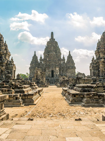 Prambanan Temple complex with ancient stone structures under a blue sky in Yogyakarta, Indonesia.