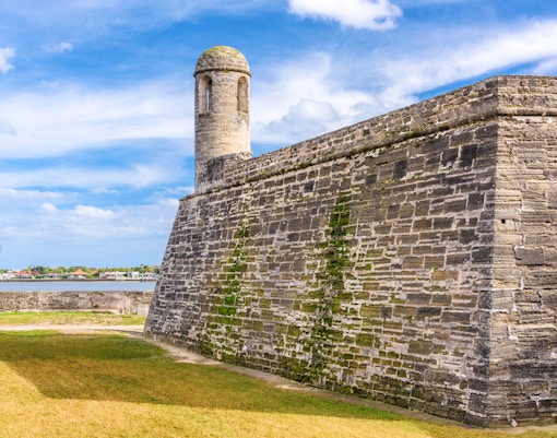 Castillo de San Marcos stone walls and watchtower, St. Augustine, Florida, with blue sky.