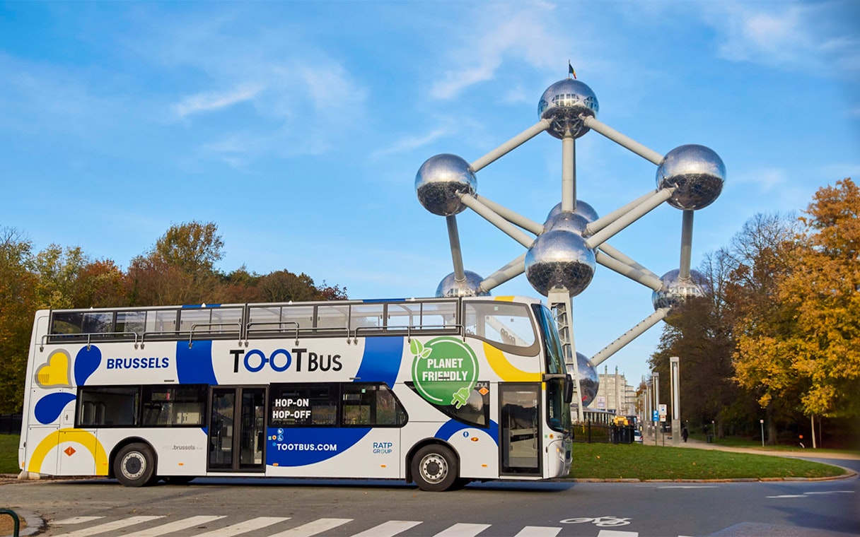 Brussels hop-on hop-off bus near Atomium landmark.