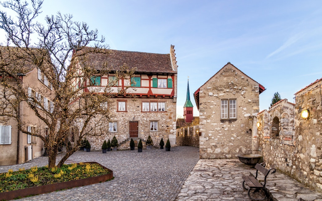 Schloss Laufen Castle courtyard with historic stone buildings at Rhine Falls, Switzerland.