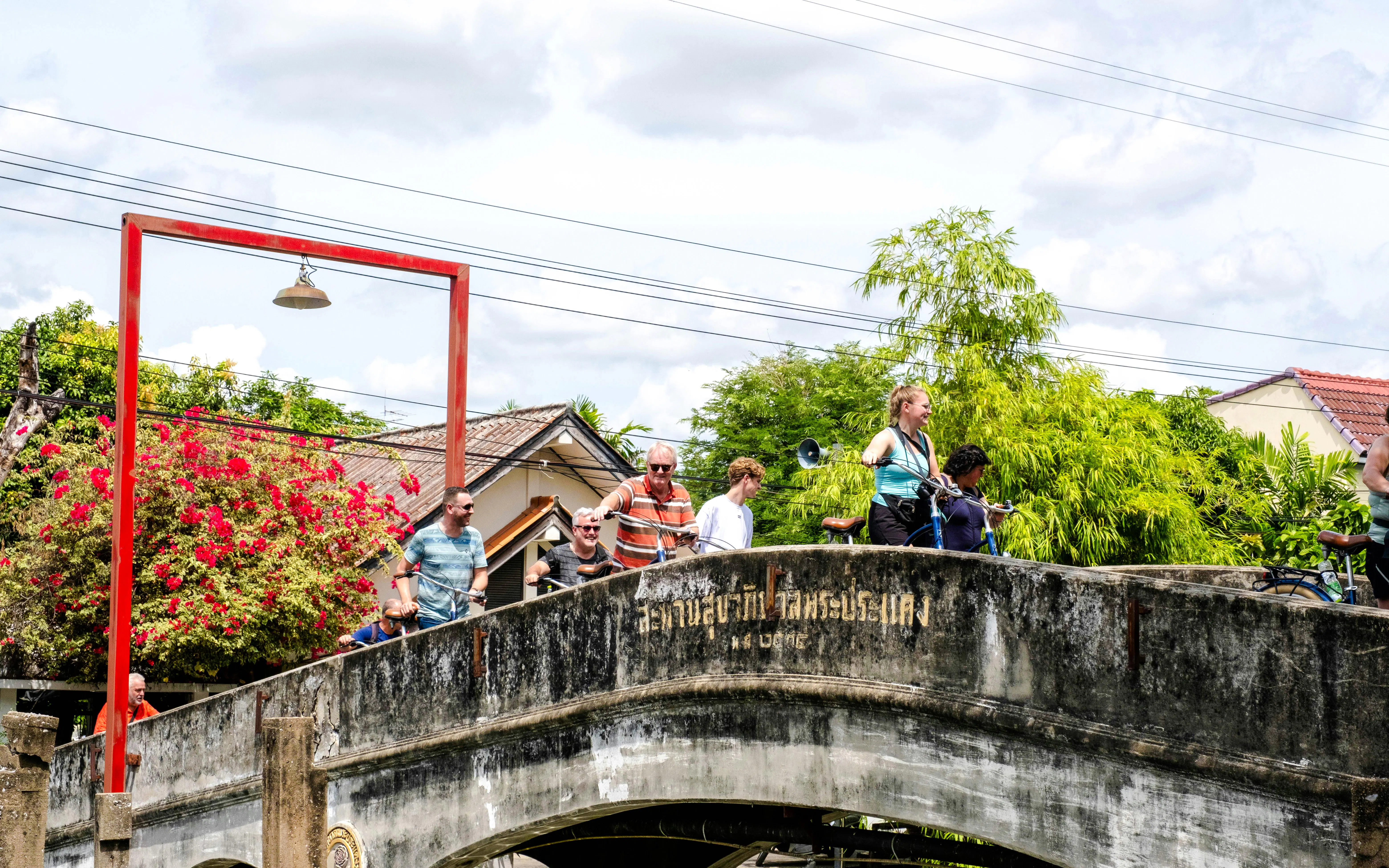 Cyclists crossing a bridge in Bangkok during a bicycle tour.