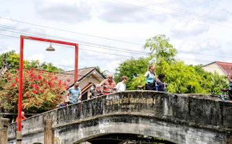 Cyclists crossing a bridge in Bangkok during a bicycle tour.