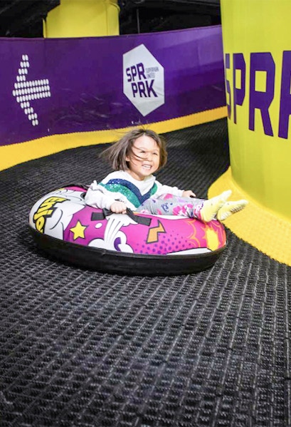 Child tubing down a slide at Super Park Malaysia.