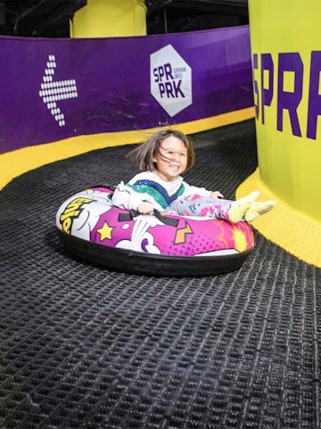Child tubing down a slide at Super Park Malaysia.