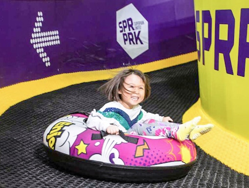 Child tubing down a slide at Super Park Malaysia.