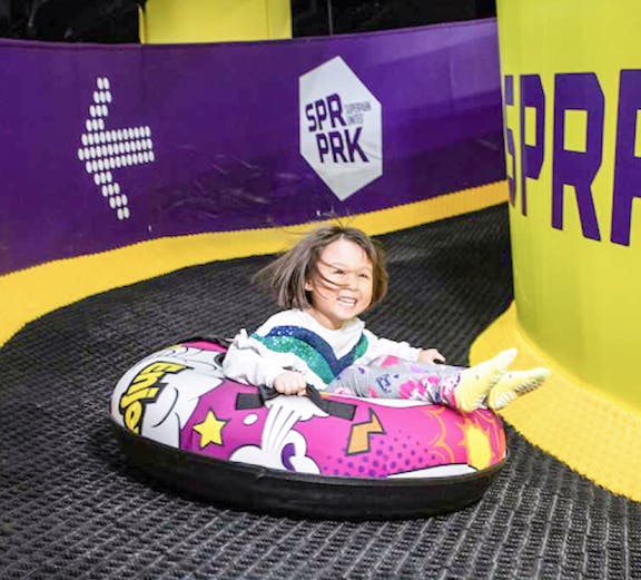 Child tubing down a slide at Super Park Malaysia.