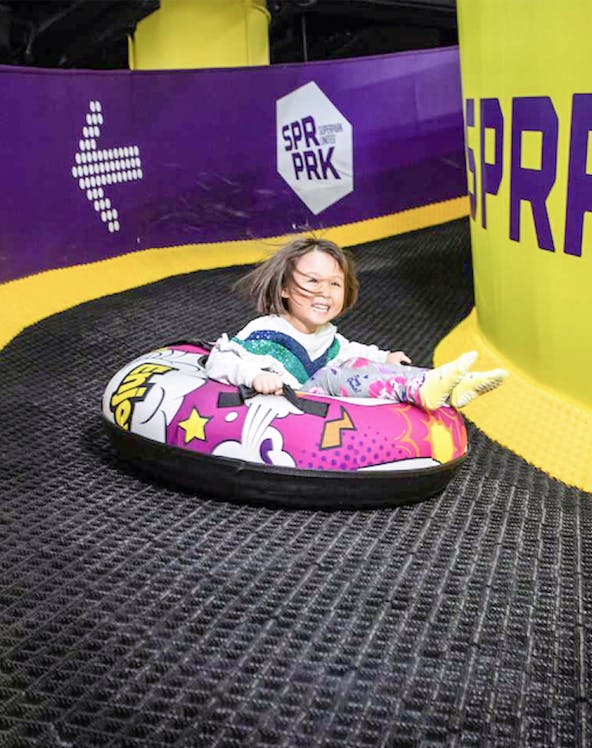 Child tubing down a slide at Super Park Malaysia.