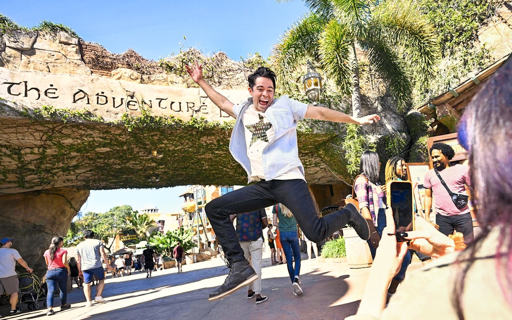Man jumping in front of Adventure Island entrance at Universal Studios Orlando.