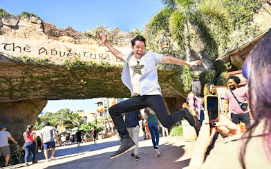 Man jumping in front of Adventure Island entrance at Universal Studios Orlando.