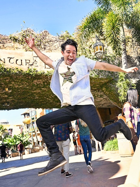 Man jumping in front of Adventure Island entrance at Universal Studios Orlando.