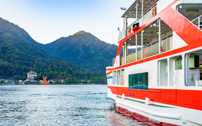 Ferry approaching Miyajima Island with view of Itsukushima Shrine's torii gate, Hiroshima.