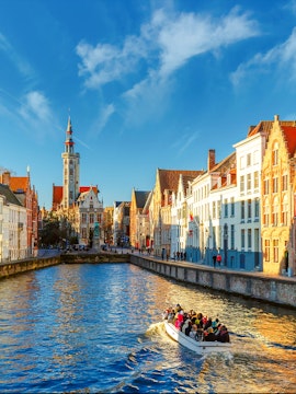 Tourist boat on Spiegelrei canal near Jan Van Eyck Square, Bruges, Belgium.