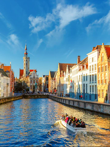 Tourist boat on Spiegelrei canal near Jan Van Eyck Square, Bruges, Belgium.