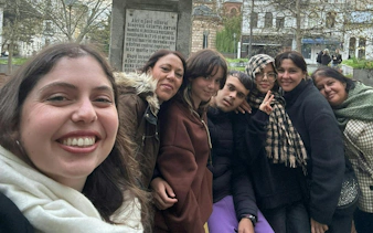 Group of people posing near a historical monument in Bucharest during a haunted city exploration game.