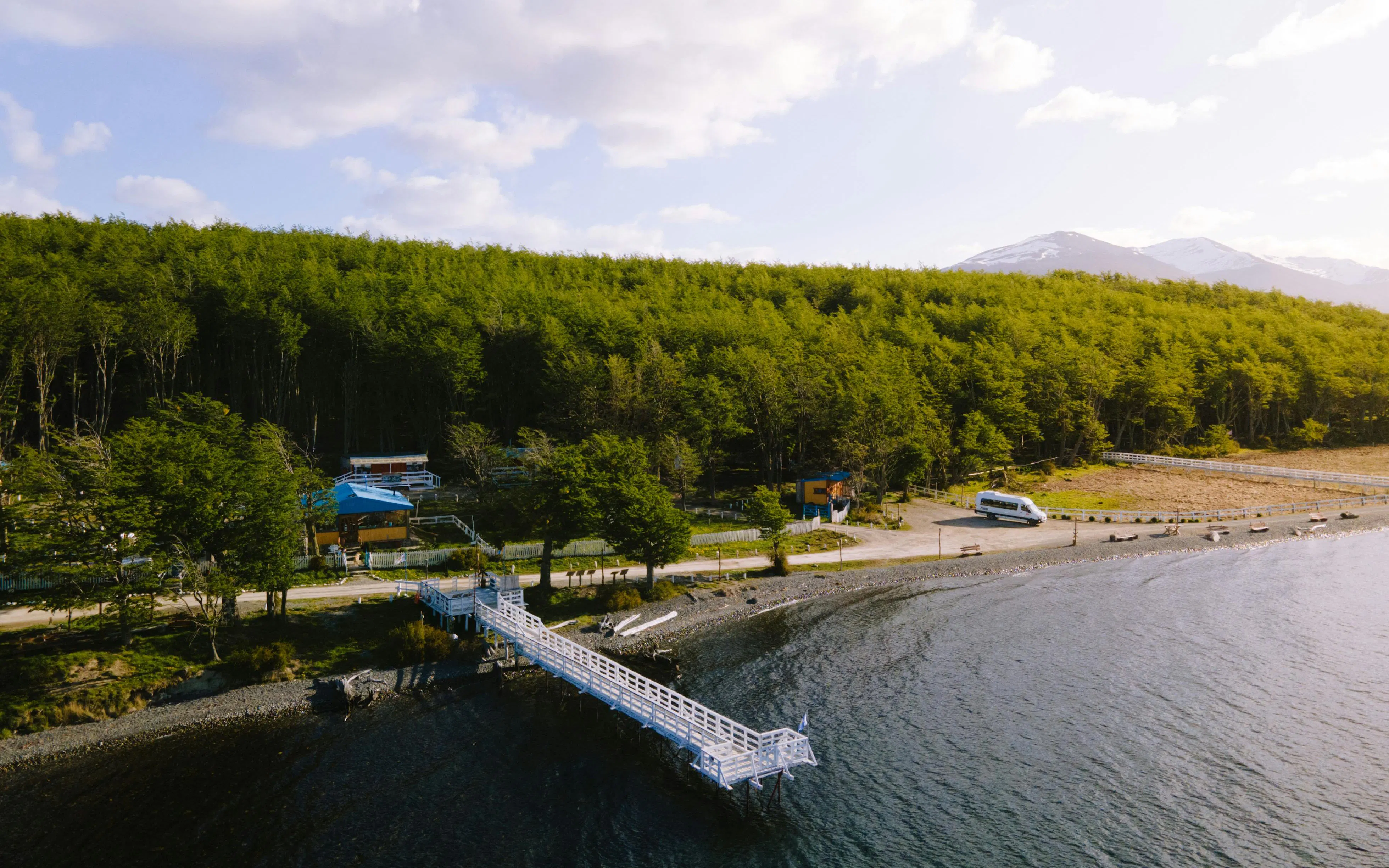 Aerial view of a pier and forested shoreline at Lake Fagnano, Tierra del Fuego, Argentina.