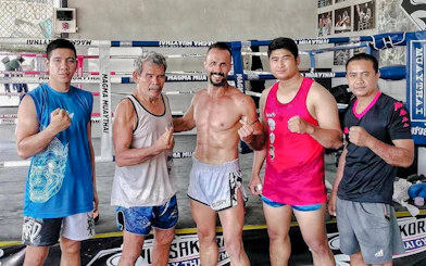 Muay Thai instructors and students in a boxing ring during a beginner class in Pattaya.