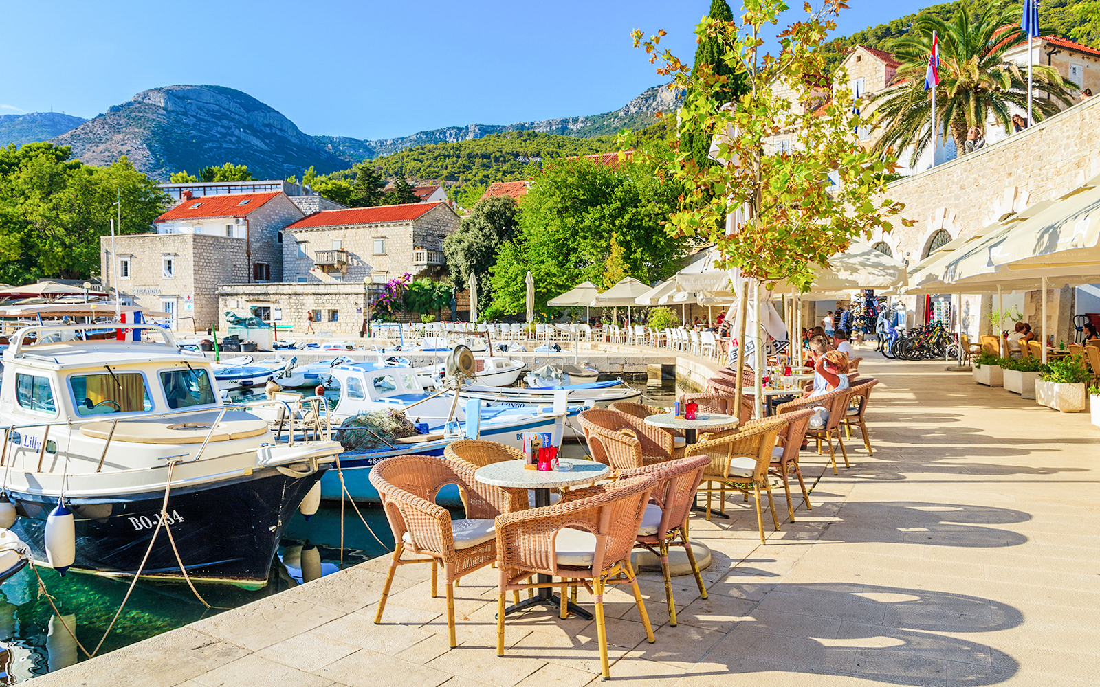 Harbor view with boats and outdoor café seating on Hvar Island, Croatia.
