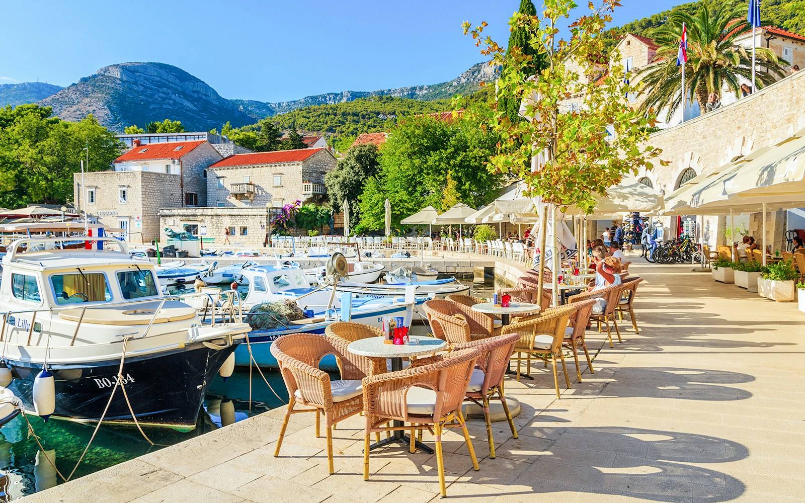 Harbor view with boats and outdoor café seating on Hvar Island, Croatia.