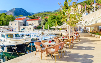Harbor view with boats and outdoor café seating on Hvar Island, Croatia.