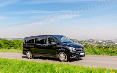 Black van on a scenic road, used for Auschwitz Birkenau AC transfer.