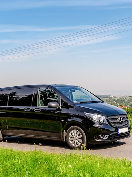 Black van on a scenic road, used for Auschwitz Birkenau AC transfer.