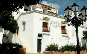 Benalmádena Pueblo library exterior with traditional architecture and street lamps.