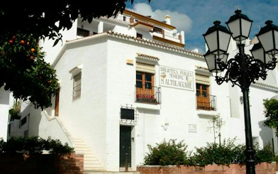 Benalmádena Pueblo library exterior with traditional architecture and street lamps.
