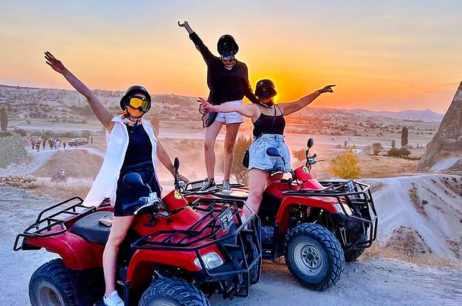 ATV riders enjoying a sunset tour in Cappadocia with scenic views and rocky landscapes.
