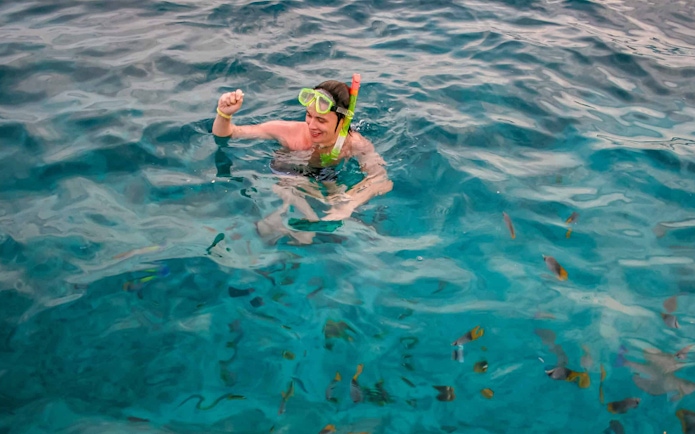 Snorkeler in clear Red Sea waters near Giftun Island, Hurghada, with colorful fish.