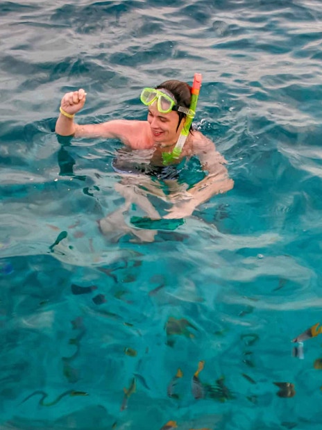 Snorkeler in clear Red Sea waters near Giftun Island, Hurghada, with colorful fish.