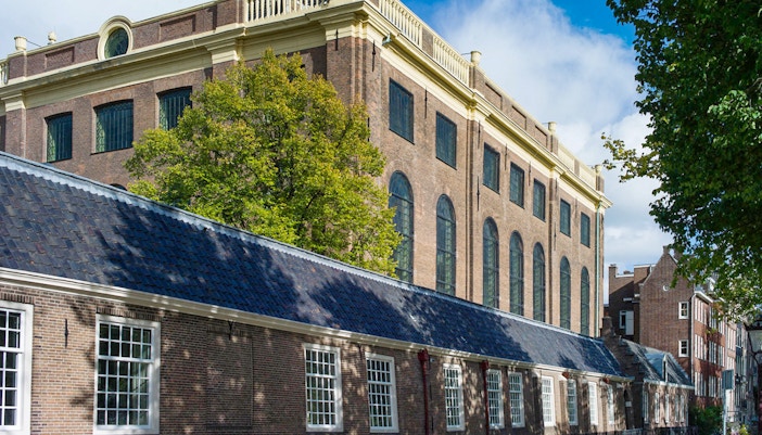 Exteriors of the Portuguese Synagogue in Amsterdam with brick facade and arched windows.