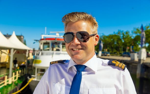 Guide in uniform at Rotterdam Historical Cruise dock.