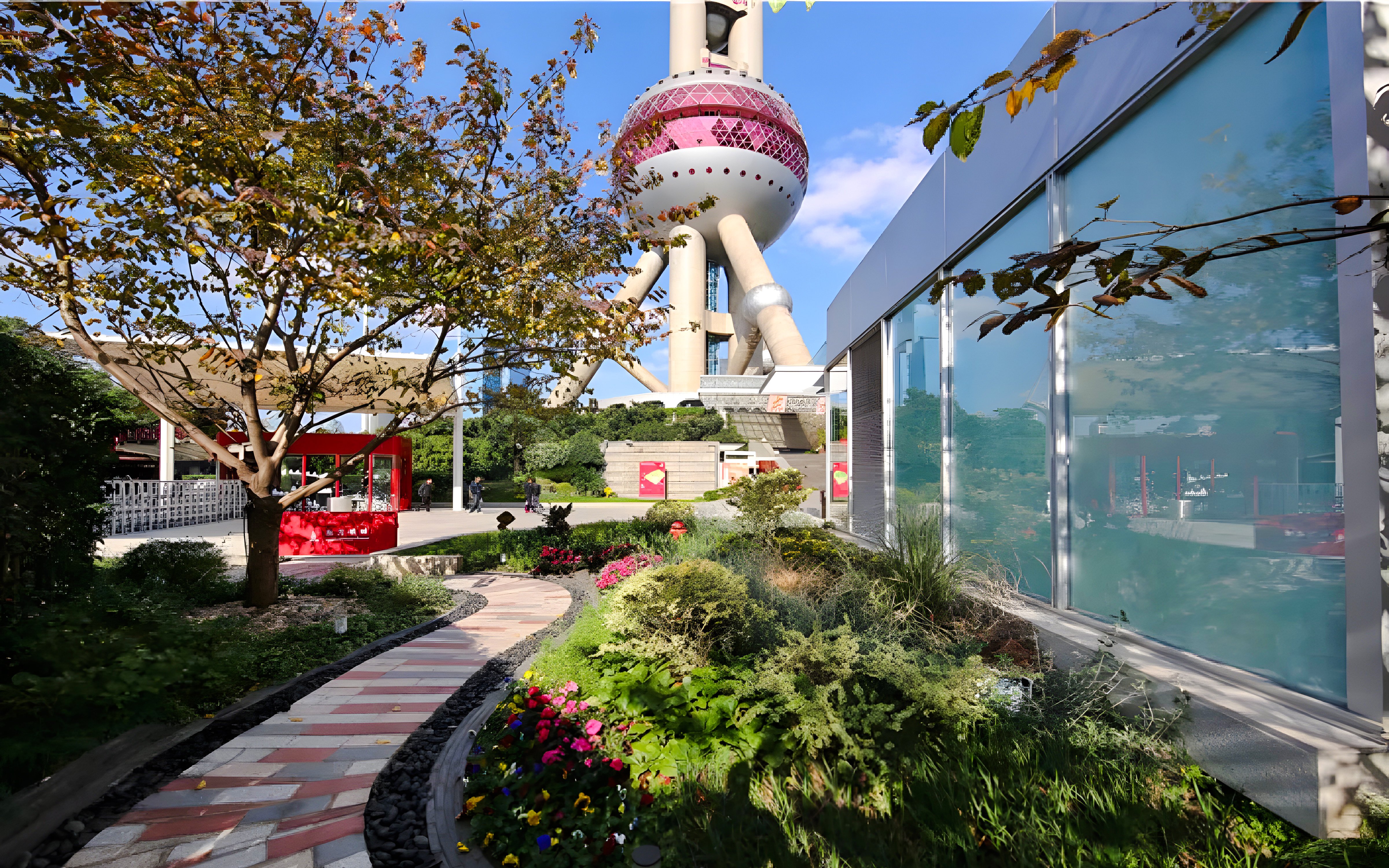 Ground floor view of Oriental Pearl Tower, Shanghai, with garden path and modern architecture.
