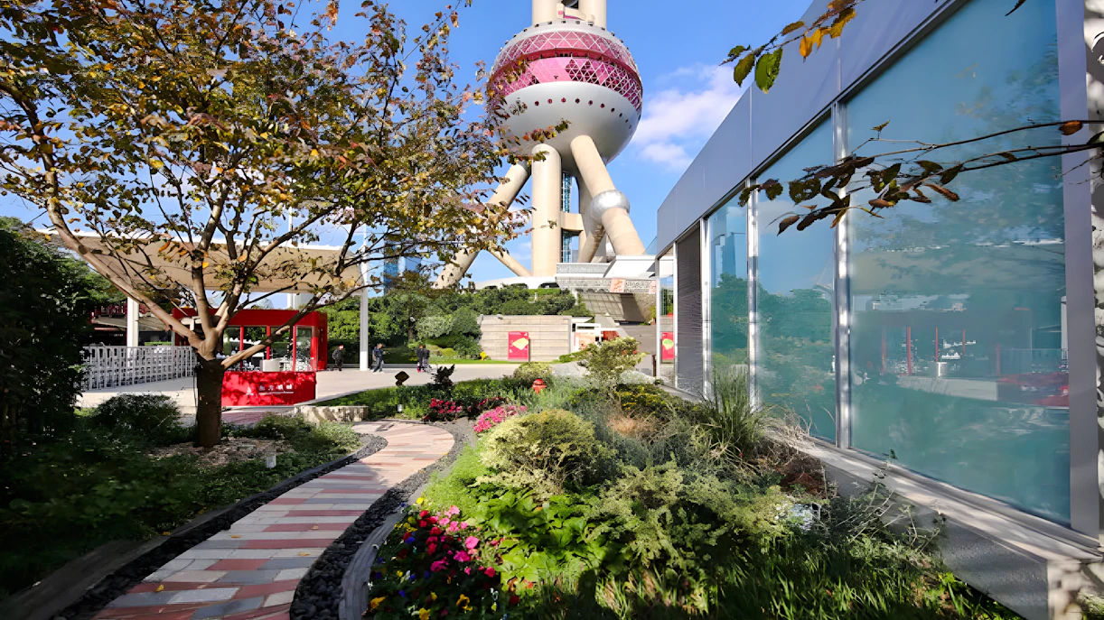 Ground floor view of Oriental Pearl Tower, Shanghai, with garden path and modern architecture.