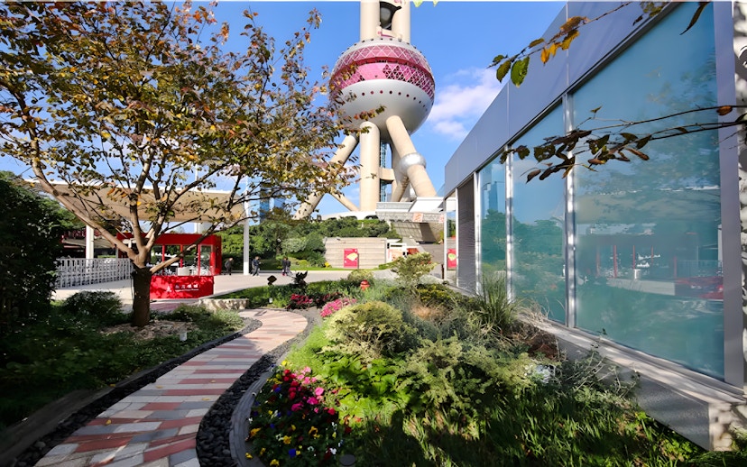 Ground floor view of Oriental Pearl Tower, Shanghai, with garden path and modern architecture.