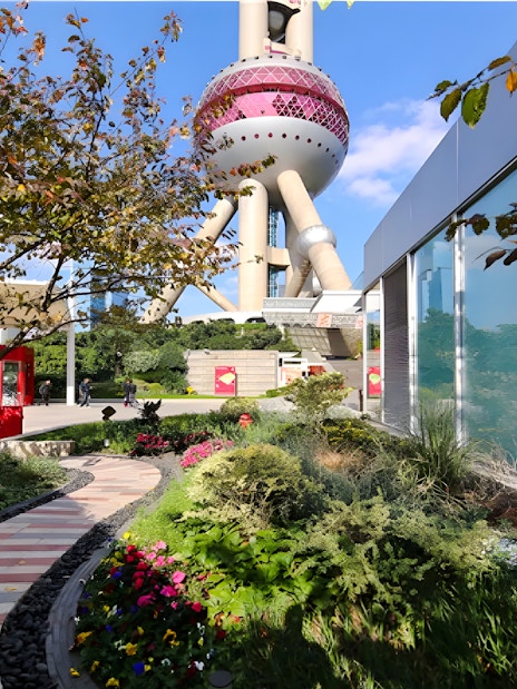 Ground floor view of Oriental Pearl Tower, Shanghai, with garden path and modern architecture.