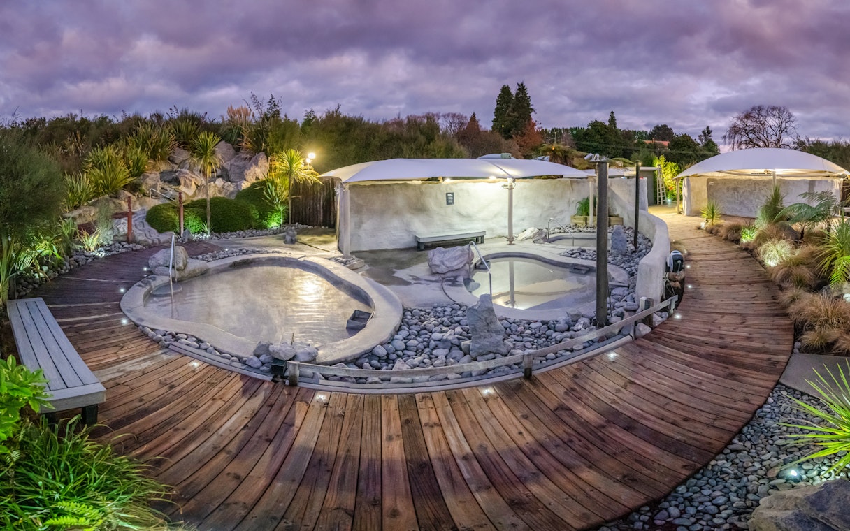 Hell's Gate geothermal mud bath area with wooden walkway and surrounding greenery.