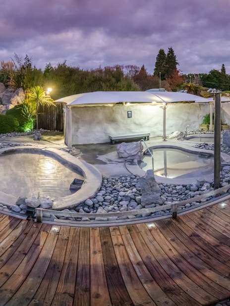 Hell's Gate geothermal mud bath area with wooden walkway and surrounding greenery.