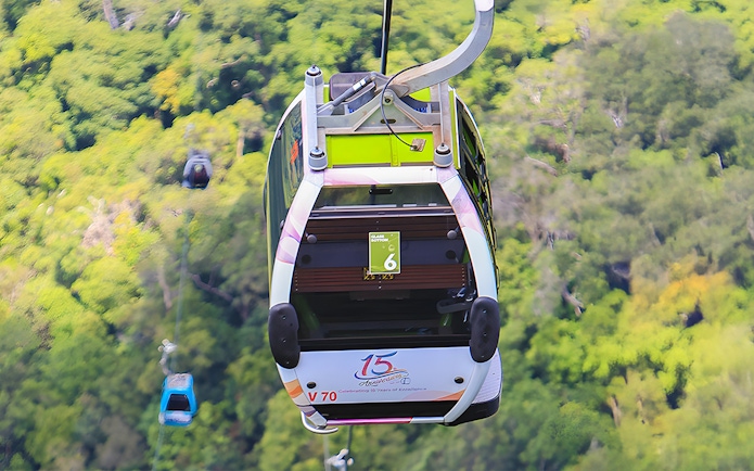 Glass bottom cable car over lush forest during Langkawi cable car tour.