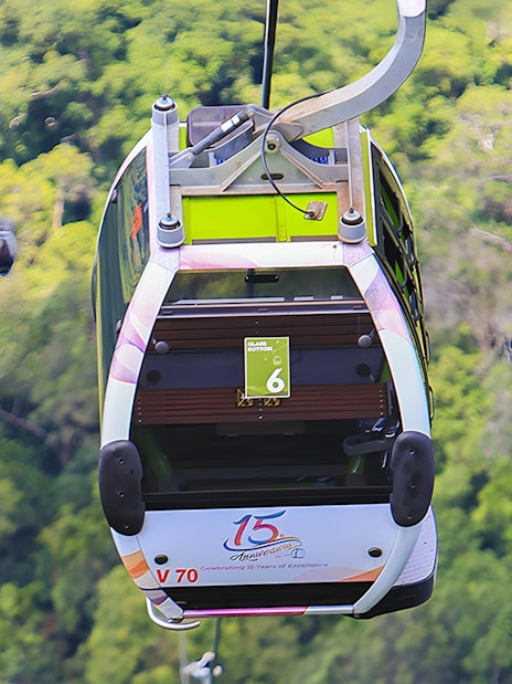 Glass bottom cable car over lush forest during Langkawi cable car tour.