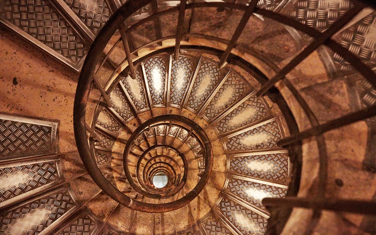 Spiral staircase inside Arc de Triomphe, Paris, viewed from above.