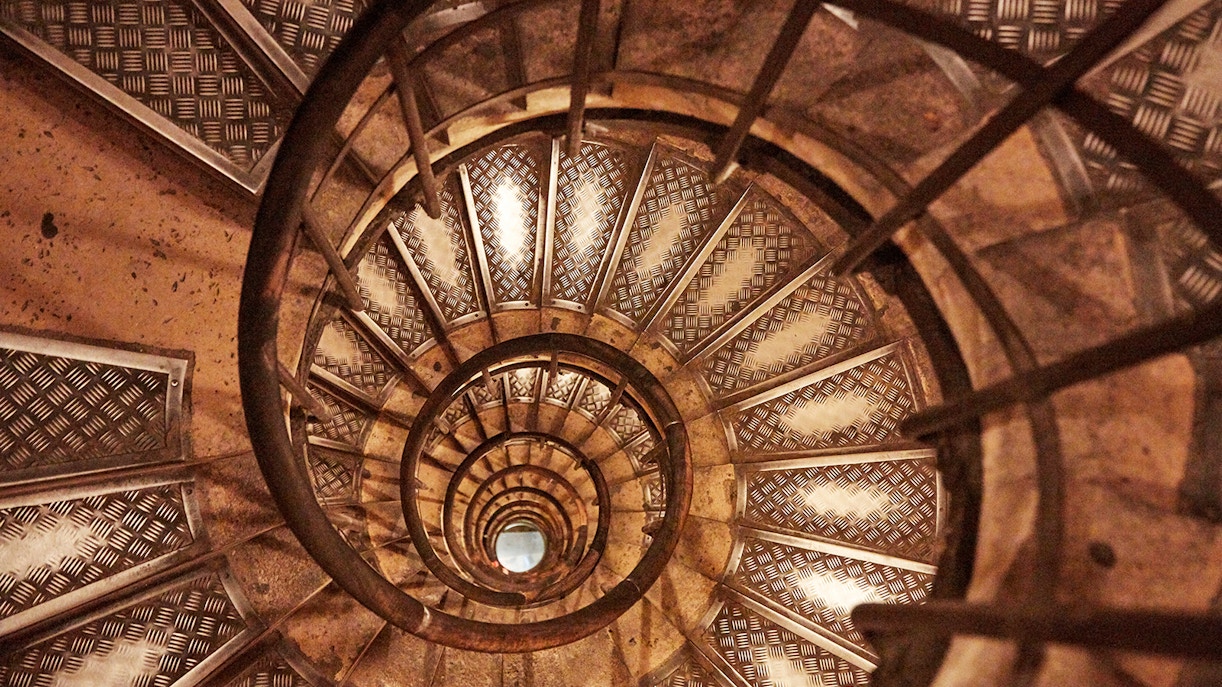 Spiral staircase inside Arc de Triomphe, Paris, viewed from above.