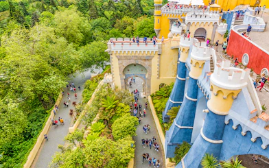 Visitors exploring the colorful architecture of Pena Palace, Sintra, Portugal.