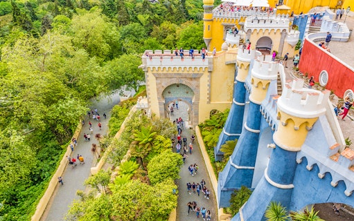 Visitors exploring the colorful architecture of Pena Palace, Sintra, Portugal.