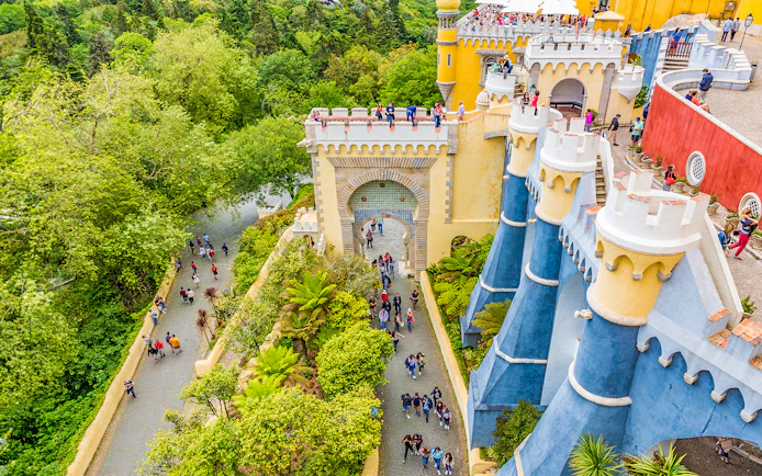 Visitors exploring the colorful architecture of Pena Palace, Sintra, Portugal.