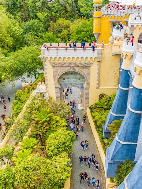 Visitors exploring the colorful architecture of Pena Palace, Sintra, Portugal.
