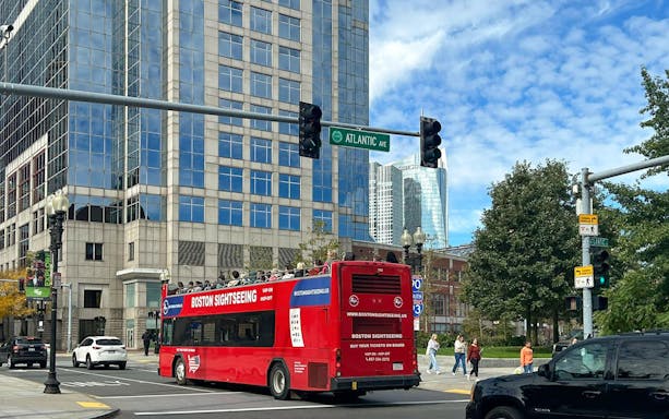 Red Boston sightseeing bus on Atlantic Avenue during hop-on hop-off tour.