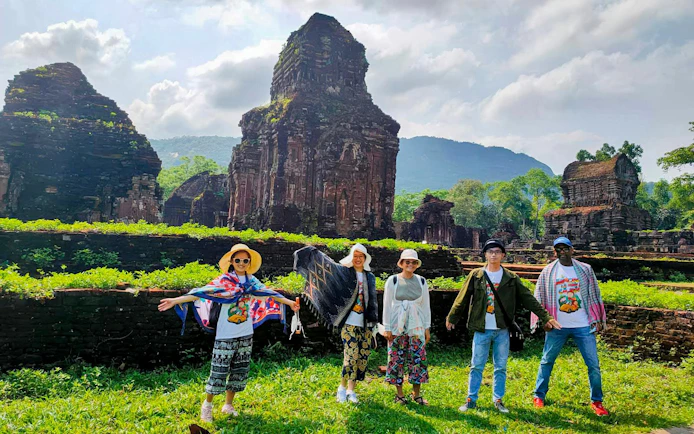 Tourists exploring ancient ruins at My Son Sanctuary, Vietnam.