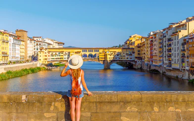Traveler admiring Ponte Vecchio over the Arno River on the Best of Florence Walking Tour.