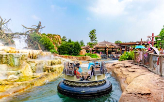 Raft on water ride at Shanghai Disneyland with waterfall and spectators.